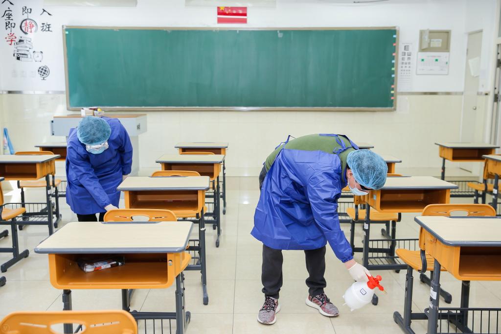 午间学生用餐前,消杀组老师使用消毒液喷洒地面